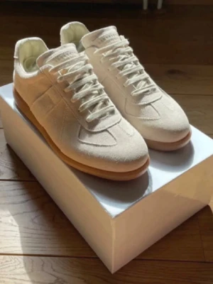 Beige sneakers i mocka med gummisula - Stilrena beige sneakers i mocka med klassisk låg silhuett och gummisula. Skorna har ton-i-ton snörning och diskreta sömdetaljer på sidan. Perfekta för dig som gillar minimalistisk och clean stil.