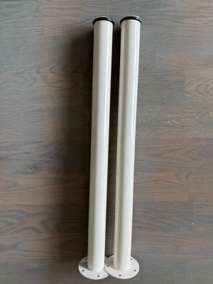 Vita metallben till bord - Två stycken vita, cylinderformade bordsben i metall med rund fot och förborrade hål för enkel montering. Passar perfekt till att bygga eget bord eller byta ut befintliga ben. Snygg och stilren design som funkar i de flesta miljöer.