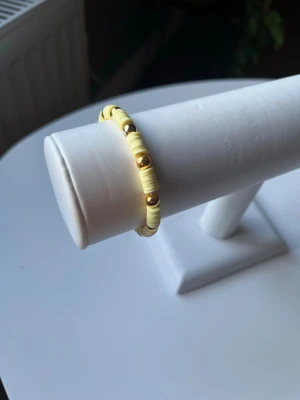 Gult armband - Ett gult somrigt armband som är handgjort. Elastiskt band så det är lätt att ta på och av.