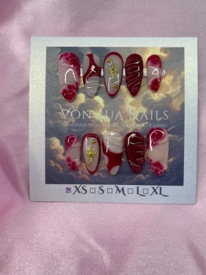 SweetBite (XS);Medium Almond - Unika handgjorda press-on naglar i rött och nude med 3D-nailart, guldfärgade stjärndetaljer och röda handmålade linjer. Mixade mönster som ger en cool och kreativ look. Perfekta för dig som vill sticka ut med handgjorda detaljer.XS: 14 mm, 11 mm, 11,5 mm, 10 mm, 8 mm 