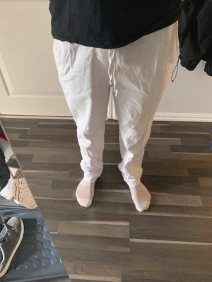 Linnebyxor  - Snygga vita linnebyxor med avslappnad passform och dragsko i midjan. Byxorna har raka ben och är tillverkade i ett lätt och luftigt linnematerial, perfekta för varma dagar. Enkla att matcha med både t-shirt och skjorta. XS från only & sons.