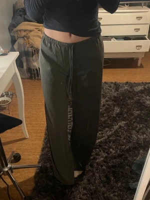 Grå kostymbyxor  - Säljer ett par grå kostymbyxor med raka ben och resår i midjan samt dragsko för skön passform. Byxorna är i ett stretchigt material. Köpta på H&M, mycket bra skick. Passar även som stl S.