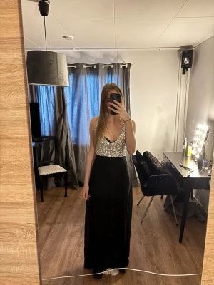 Balklänning med paljetter - Jättefin och enkel balklänning med v-ringning i storlek L, men passar mer som M.