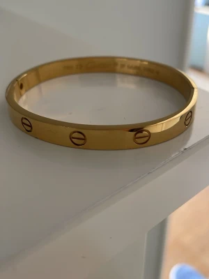 C armband i guld - Säljer ett ikoniskt C armband i guld. Armbandet har den klassiska skruvdesignen. Perfekt för dig som gillar exklusiva och tidlösa smycken med lyxig känsla.