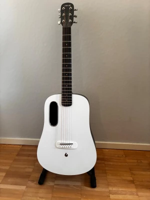 Vit akustisk gitarr från LAVA ME - Säljer en modern akustisk gitarr från LAVA ME i vit och svart design. Gitarren har en unik oval ljudhål, slimmad kropp och greppbräda i mörkt trä. Kroppen är tillverkad i kompositmaterial och har en stilren, minimalistisk look. Gitarr bag på köpet. Hämta I Leksand helst men kan frakta