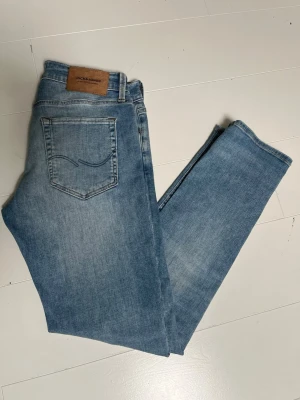 Ljusblå slim fit jeans Jack & Jones - Säljer ett par ljusblå slim fit jeans från Jack & Jones. Klassisk femficksmodell med snygg skinnpatch bak i midjan. Jeansen har normalhög midja och raka ben. Perfekta till en avslappnad stil. Storlek 29 - 30