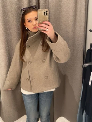 Beige ullkappa med dubbelknäppning - Stilren beige kappa i ullmix med dubbelknäppning framtill och hög krage från Gina tricot i storlek Xs💕 aldrig använd, skitsnygg och eftertraktad