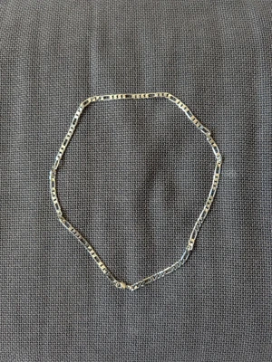 Kedjehalsband i silverfärgad metall - Stilrent halsband med platt kedja i silverfärgad metall. Kedjan har ett klassiskt, rektangulärt länk-mönster och enkel karbinhake. Perfekt för dig som gillar minimalistiska accessoarer.