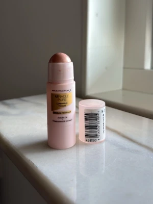 Max Factor Miracle Pure Highlighter - Krämig highlighter i stickform från Max Factor, Miracle Pure Luminous Touch. Ger en glowig finish med en ljusrosa ton. Innehåller jojobaolja och granatäppleextrakt. Färgen 15 rosé gold. Använd 1 gång 