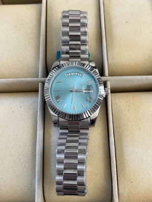 Ekstrand DayDate Ljusblå/Silver - Stilren klocka från med president armband i silver med en ljusblå urtavla, skriv vid funderingar 