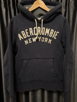Abercrombie & Fitch hoodie  - A&F hoodie - skick 8/10, fint skick! - storlek S - sjukt snygg och skön tröja, passar när som helst! VÄLDIGT EFTERTRAKTAD - Att den är lite sliten på vissa ställen, som på bild 5, är design, den ska alltså vara så - hör av er vid funderingar🙌