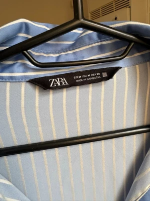 Oversized skjorta från Zara  - Snygg oversized skjorta från Zara, blå med vita ränder och guldknappar som gör den extra lyxig 