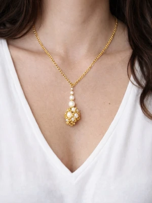 Guldhalsband med pärlor -  halsband med guldfärgad kedja och ett hängsmycke med vita och guldiga pärlor. Bilden med tjejen som har på halsbandet är ai endast för att visa hur den ser ut på 💕