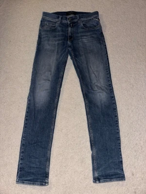Blå Replay Jeans  - Säljer ett par klassiska blå jeans från Replay, modell Wallys. Jeansen har en rak passform på benen och snygga backfickssömmar. Perfekta till vardags för en avslappnad look.