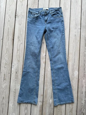 Blå bootcut jeans från Gina Tricot. 38.  - Ett par klassiska blå bootcut jeans från Gina Tricot med fem fickor och normal midja. Jeansen har en lätt utsvängd passform nedtill och är tillverkade i mjukt denimtyg.. Storlek 38. Från Zara. 99% bomull, 1% elastan = lite stretch.  Knappt använda och i jättefint skick. Finns inga fel eller slitningar. 