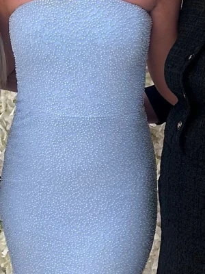 Ljusblå axelbandslös långklänning - Snygg axelbandslös långklänning i ljusblått med figurnära passform. Klänningen har en elegant och stilren look, perfekt för speciella tillfällen. Från ohpolly. Passar 34/36. 