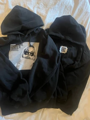 Svarta odz hoodies - Två svarta hoodies från ODZ med huva och snygga tryck .Perfekt för dig som gillar streetwear och snygga prints.