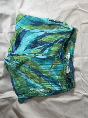 Färgglada mönstrade shorts från H&M - Säljer ett par lätta och luftiga shorts från H&M med elastisk midja och snörning. 
