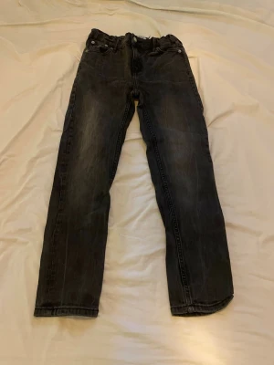 Svarta jeans från 157 New Classic Star - Svarta jeans med lätt tvättad look och resår i midjan från 157 New Classic Star. Klassisk femficksmodell med raka ben och knappgylf. Perfekta för en avslappnad och trendig stil.