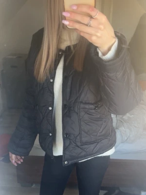 Svart jacka med knappar - Snygg svart quiltad jacka med knappar framtill och två fickor. Fråm vila storlek xs