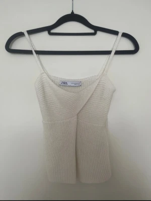 Vit stickad omlottopp från Zara - Supersöt vit stickad topp från Zara med omlottdesign och smala axelband. Passar XS/XXS