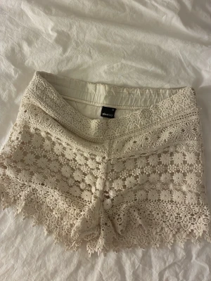 Spets shorts - Spets shorts från Ginatricot. Finns ej bild på då midjebandet inte har stretch och inte kommer högre upp än låren på mig. Därav har de även spruckit i sidan av bandet, men inget som syns på. Säljer såklart inte fullpris. 