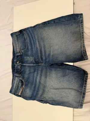 Diesel Denim Jeansshorts  - Riktigt schyssta jeansshorts i klassisk mellanblå tvätt. Modell med Regular Fit och snygg, naturlig slitning. Mycket fint skick och sparsamt använda. Garanterat äkta med Certilogo-tagg. 📦 Skickas direkt!