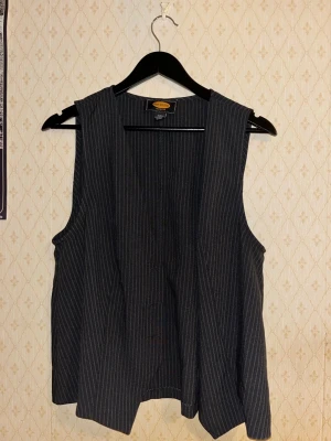 Randig svart väst från Urban Outfitters - Striped black-grey V-neck vest from Urban Outfitters. 3 buttons, used only couple times