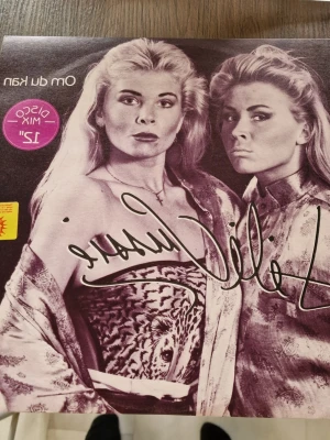 Lili & Susie Om du kan singel - Vinylsingel med Lili & Susie, titeln 'Om du kan' och 'Ängel'. Omslaget har svartvita bilder på artisterna och tydliga 80-talsvibbar. Skivan är utgiven av EMI Svenska AB 1985 och har en klassisk retrostil med rosa detaljer. Inga repor.