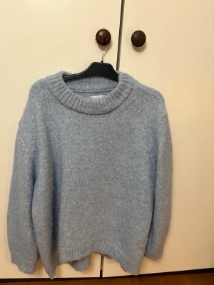 Ljusblå stickad tröja ASOS DESIGN - Mysig ljusblå stickad tröja från ASOS DESIGN med rund halsringning och bred ribbad kant. Perfekt för lager-på-lager och chill dagar. Tröjan har en avslappnad passform och är superenkel att styla till jeans eller kjol. Slutsåld på hemsidan 