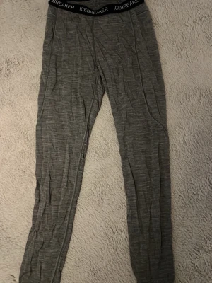 Grå underställ från Icebreaker - Säljer ett par grå underställ från Icebreaker, modell BodyfitZONE. De är tillverkade i ett mjukt och stretchigt material, perfekt för lager-på-lager. Resår i midjan med logga och smala ben. Grymma för dig som gillar outdoor eller träning.