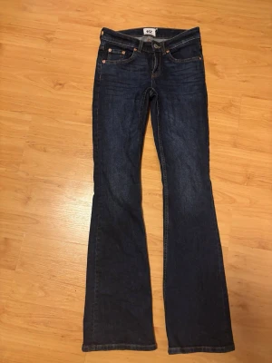 Mörkblå bootcut jeans från 157 - Snygga mörkblå bootcut jeans från lager157 med klassisk femficksdesign och orangea sömmar. Jeansen har normal midja och är tillverkade i ett mjukt denimtyg som sitter skönt. Perfekta för dig som gillar en tidlös och avslappnad stil. Dessa jeans original pris är 400kr (lowboot) ☺️