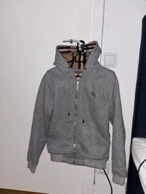 Grå burberry zip hoodie - Grå burberry zip hoodie helt fräscht använd 2-3 gånger och är nytvättad passar med en grå clean stil och har en bra passform