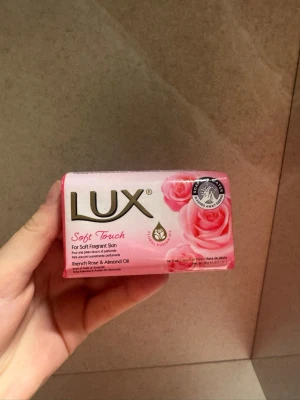 Lux Soft Touch tvål med ros & mandel - Lux Soft Touch är en fast tvål med doft av fransk ros och mandelolja. Tvålen kommer i en rosa förpackning med guldtext och rosor på framsidan. Perfekt för dig som vill ha mjuk och väldoftande hud.