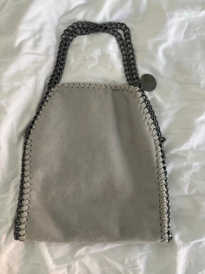 super snygg grå väska  - säljer en super snygg och cool grå väska som är använd ett få tal gånger! den har mörk gråa kedjor! kom gärna med prisförslag 