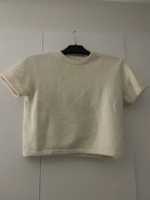Stickad kortärmad tröja  - En  rätt så tjock ljus beige stickad tröja ifrån Gina Tricot. Den är använd kanske 1-2 gånger så den är i väldigt bra skick och inga defekter. (Ser något ut som att de är missfärgning/fläckar är de ljuset. Skriv ifall ni vill ha bättre bilder) den är i storlek 146/152.