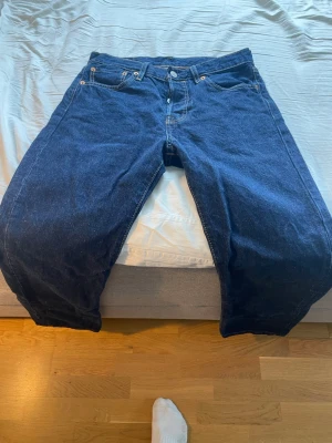 Mörkblå raka jeans - Säljer ett par mörkblå jeans med rak passform och klassiska fem fickor. Jeansen har kontrastsömmar och knappgylf. Perfekta för dig som gillar en enkel och tidlös denimlook.