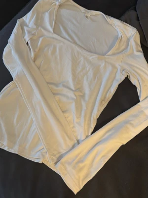 Vit långärmad topp från H&M - En enkel och stilren vit långärmad topp med rundad halsringning. Från H&M storlek xs.väsligt strechig! 