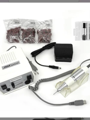 Elektrisk nagelfil  - Elektrisk nagelfil, silverfärgad handdel och tillhörande fotpedal. Inkluderar inte samma bits på bilden då dom är använda men skickar med andra som inte är använda. Perfekt för manikyr och pedikyr, passar både gel- och akrylnaglar. Elfilen är från nagelgiganten och säljs för 899kr men säljer den för 500. 20.000 rpm