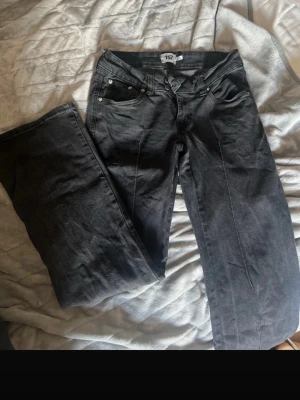 Svarta jeans från 157 Paris Crease - Säljer ett par svarta jeans från 157 Paris Crease. Klassisk femficksmodell med raka ben och normal midja. Jeansen har silverfärgade nitar och knapp, samt diskret tvättad finish. Perfekta till en avslappnad streetwear-look. Säljer pågrund av att de är för långa för mig