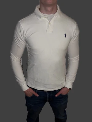 Vit långärmad piké från Ralph Lauren - Vit långärmad piké från Ralph Lauren i storlek S.  Fint skick till ett bra pris. Nypris: 1995kr. Mitt pris: 349kr. Vid frågor eller funderingar, tveka inte att höra av dig.