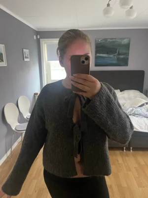 Grå fluffig stickad kofta med knyt - Mysig grå stickad kofta med fluffig textur och två knytband framtill💕