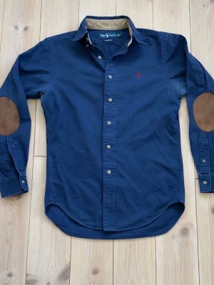 Polo Ralph Lauren Skjorta  - Unik och stilren Polo Ralph Lauren skjorta med elbow patches 💎 | Storlek S (PM för mått) | Använd, men fortfarande fin, tappat lite färg på vissa ställen som visas på bild 5. ✔️ 