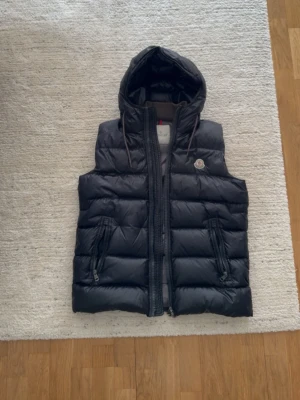 Moncler väst  - Moncler väst, storlek 4 passar nån som brukar bära M på kläder. Skick 9/10. Färg svart. Priset går att disskuteras.