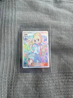 Pokémonkort Lillie Trainer Full Art #151 - Unikt Pokémonkort med Lillie Trainer Full Art-design. Kortet är från Ultra Prism och är nummer #151 i settet. Skicket av kortet är bra. Ytterst små detaljer av whitening i hörnen av kortet men annars extremt bra skick. Säljes på EBay och tradera för runt 3000-4000kr. Perfekt för samlare och Pokémonfans. Mer bilder kan skickas vid förfrågning. Svarar så snabbt som möjligt vid behov. Endast seriösa bud! 