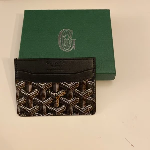 GY kortfordral  - Snyggt svart kortfodral från med klassiskt mönster i färgen svart, vitt, brunt och beige. Oanvänd!!!