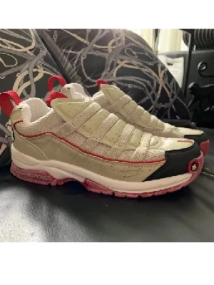 Beige och röda sneakers från Royal Elastic - Unika sneakers från Reebok i grått och beige med röda detaljer och rosa sula. Skorna har en chunky design, mesh och mockaliknande material samt svart tåparti. Perfekta för dig som vill sticka ut med coola detaljer och sportig vibe.