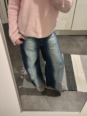 Blåa wide leg jeans  - Säljer ett par blåa wide leg jeans med låg midja och riktigt avslappnad passform. Jeansen är ”blue spray” alltså är dom vita i mitten på benen och vid gylfen. Storlek 27 i midjan och ca 152/158 i längden efter som att de är uppsydda.