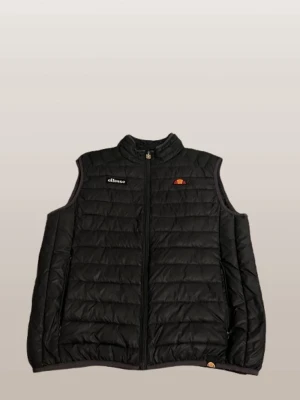 Svart dunväst från Ellesse - Snygg svart dunväst från Ellesse med quiltad design och dragkedja framtill. Västen har ståkrage och två sidofickor. Ellesse-logga broderad på bröstet. Perfekt för lager-på-lager och streetwear-stil.