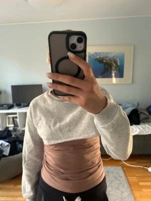 Grå croppad sweatshirt  - Säljer en grå croppad sweatshirt. Tröjan har rund halsringning, långa ärmar och ribbade muddar. Perfekt för en avslappnad och trendig look. Materialet är mjukt och bekvämt, troligen bomullsblandning. Enkel och stilren design utan tryck eller detaljer.